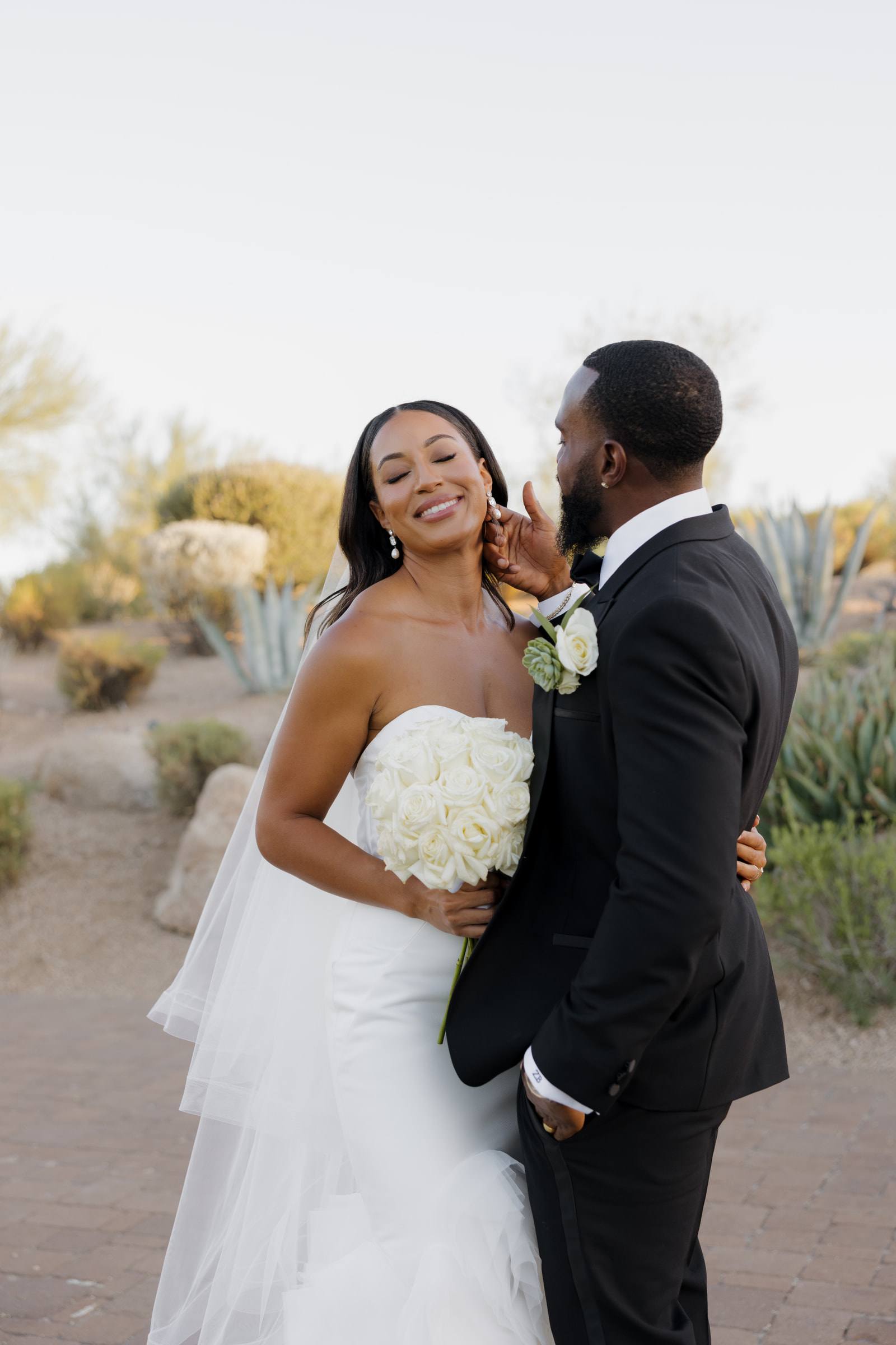 A smiling bride with her groom in the Arizona desert