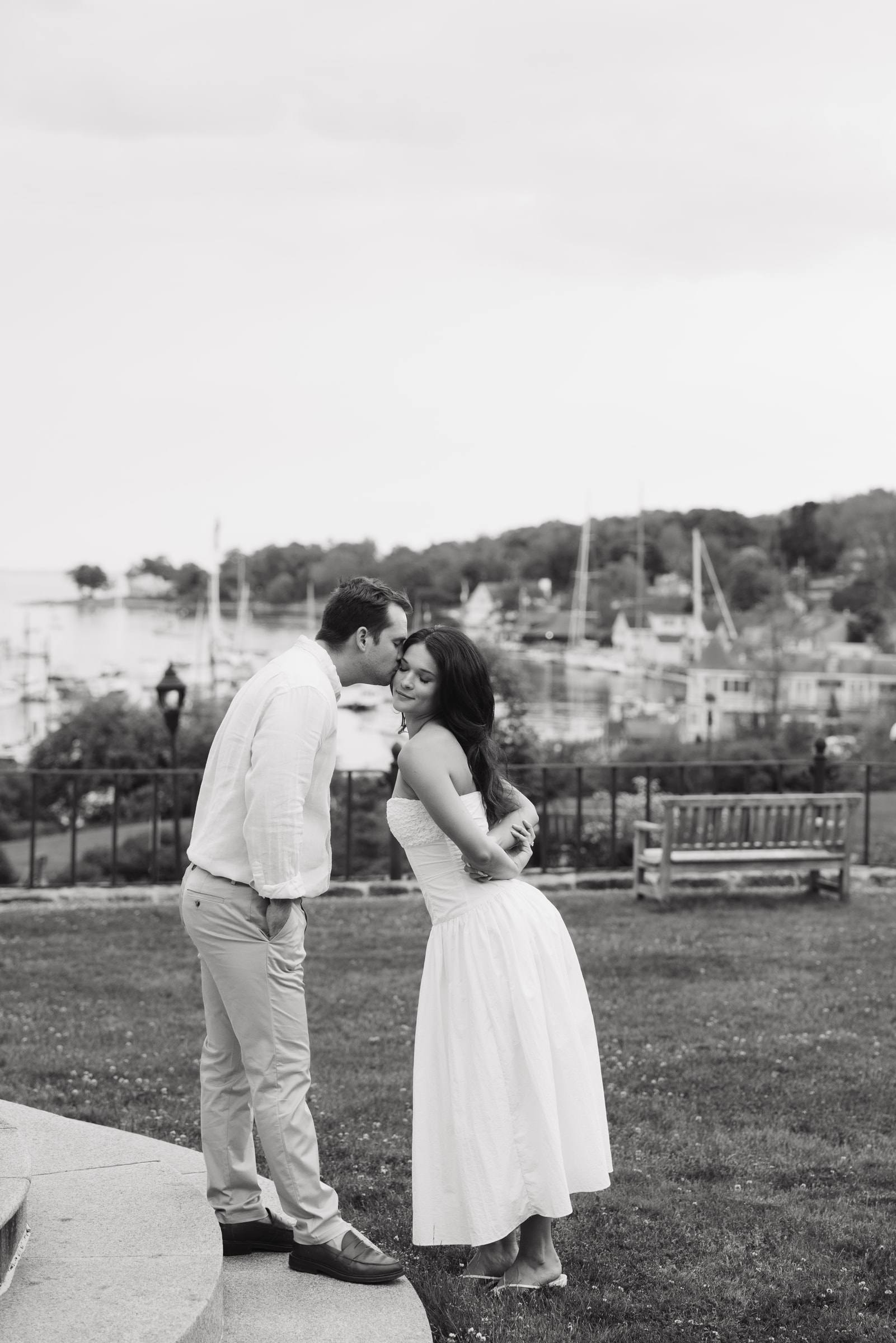 A couple sharing a kiss above a harbour, in black and white