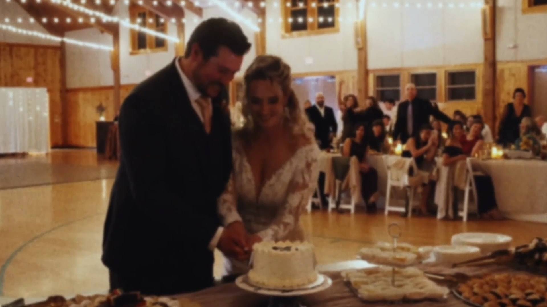 A bride and groom cutting their wedding cake at a candlelit reception, from a Super8 film