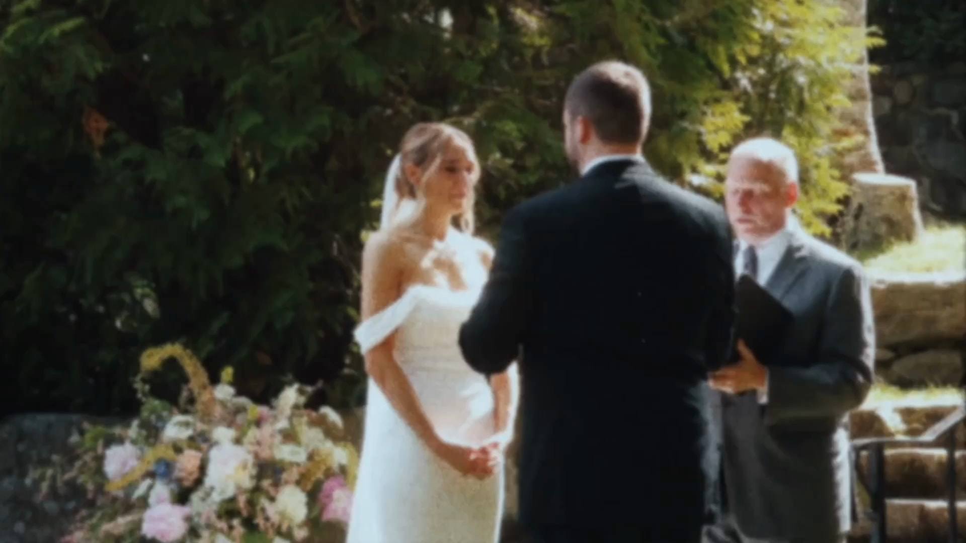 A bride listening to her groom during their garden ceremony, from a Super8 film